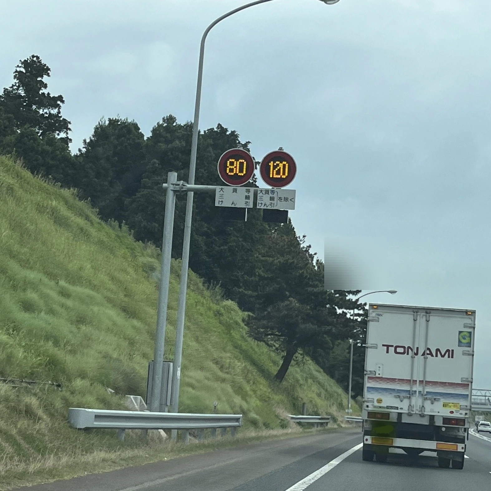 大型車と速度規制標識の実写写真